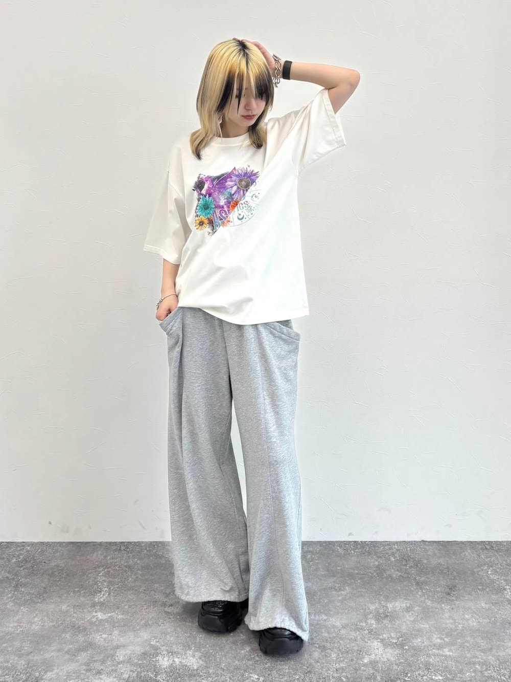 ブラック系のスニーカー、グレー系のスウェットパンツ、ホワイト系のTシャツ/カットソーを着用したレディースの春コーディネートの3枚目の写真