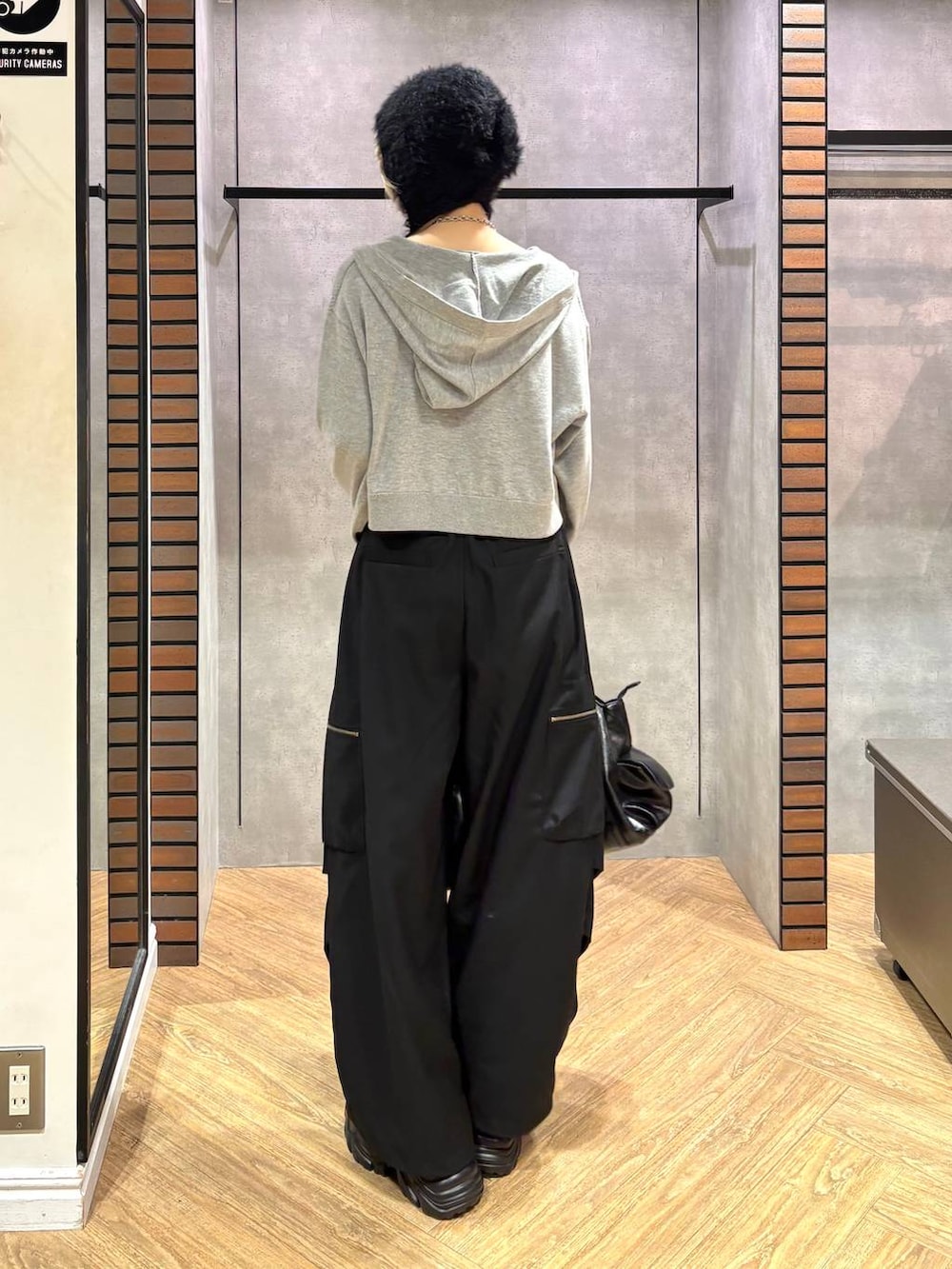 グレー系のパーカー、ブラック系のスニーカー、ブラック系のシャツ/ブラウスを着用したレディースの秋コーディネートの4枚目の写真