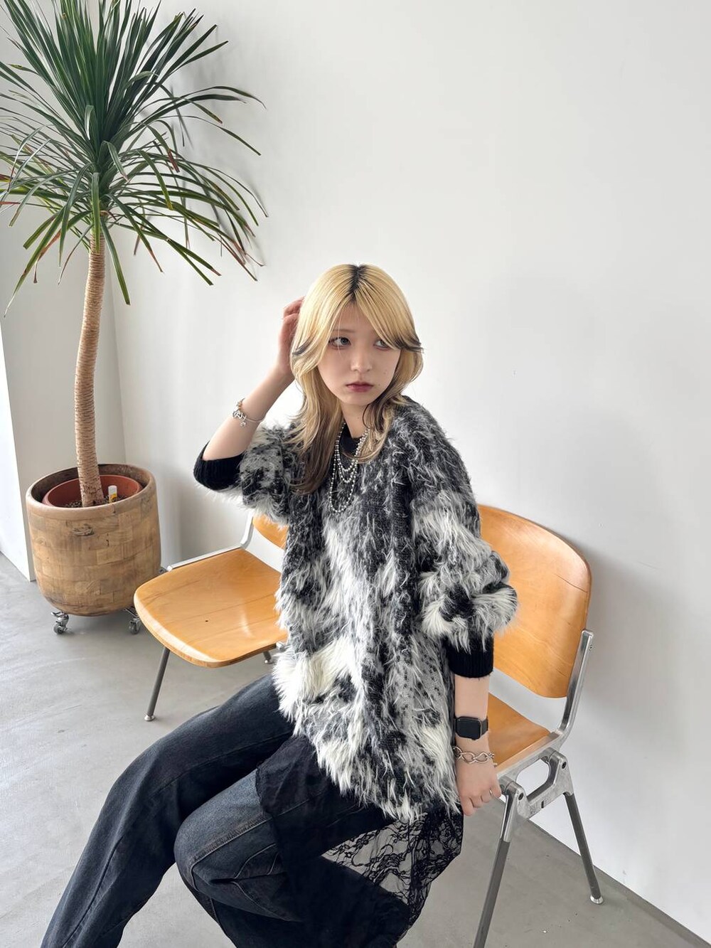 ブラック系のニット/セーター、ブルー系のデニムパンツ、その他のサンダルを着用したレディースの夏コーディネートの4枚目の写真
