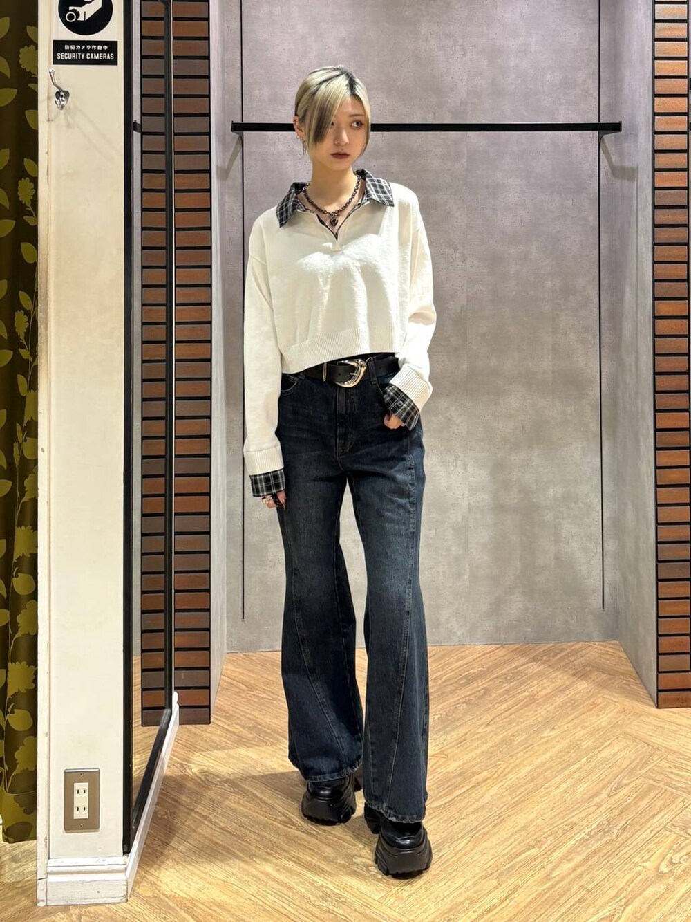 ブラック系のスニーカー、ブルー系のデニムパンツ、ホワイト系のニット/セーターを着用したレディースの秋コーディネートの2枚目の写真