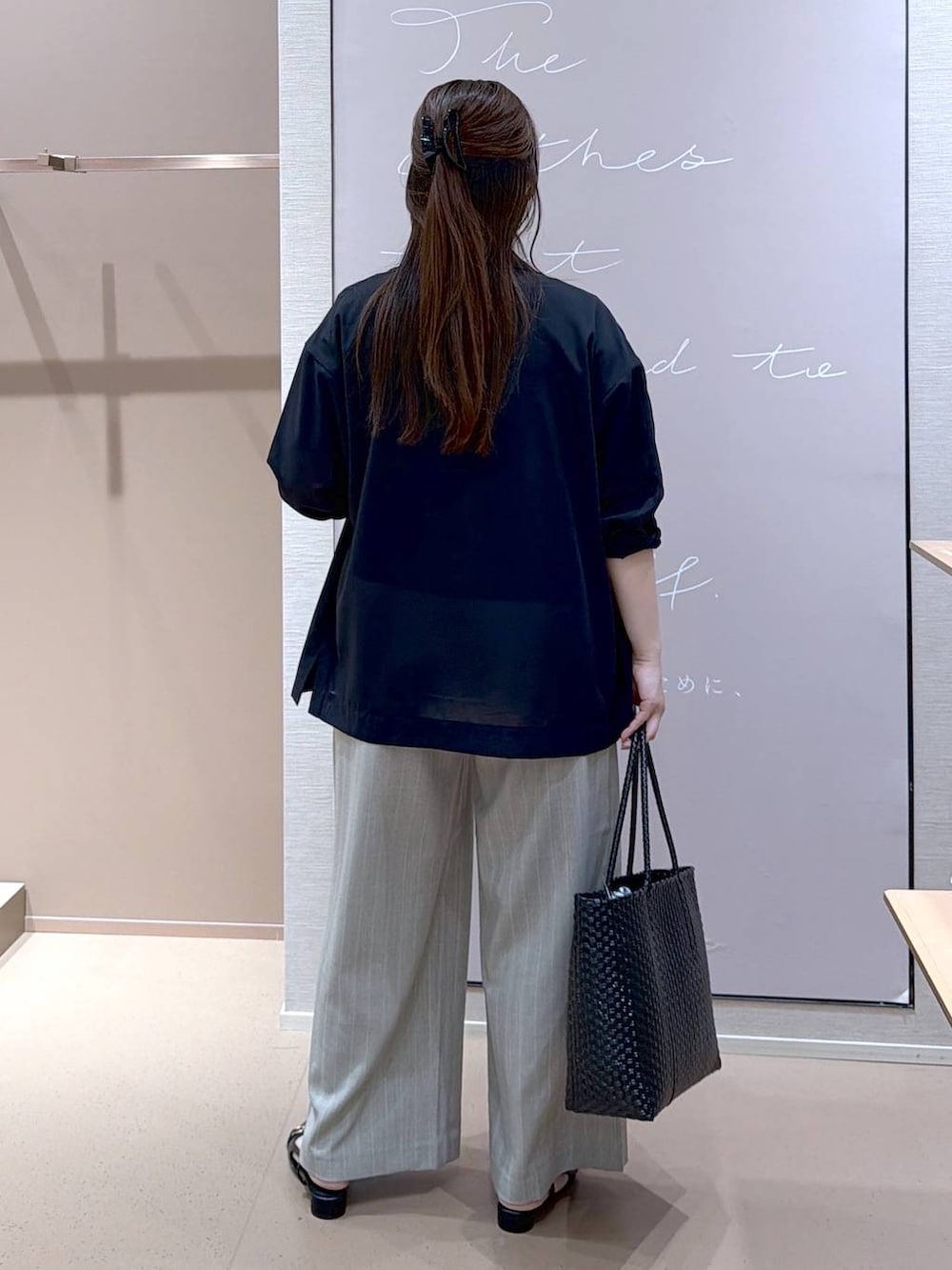 ブラック系のパンプス、ブラック系のテーラードジャケット、ブラック系のかごバッグを着用したレディースの夏コーディネートの3枚目の写真