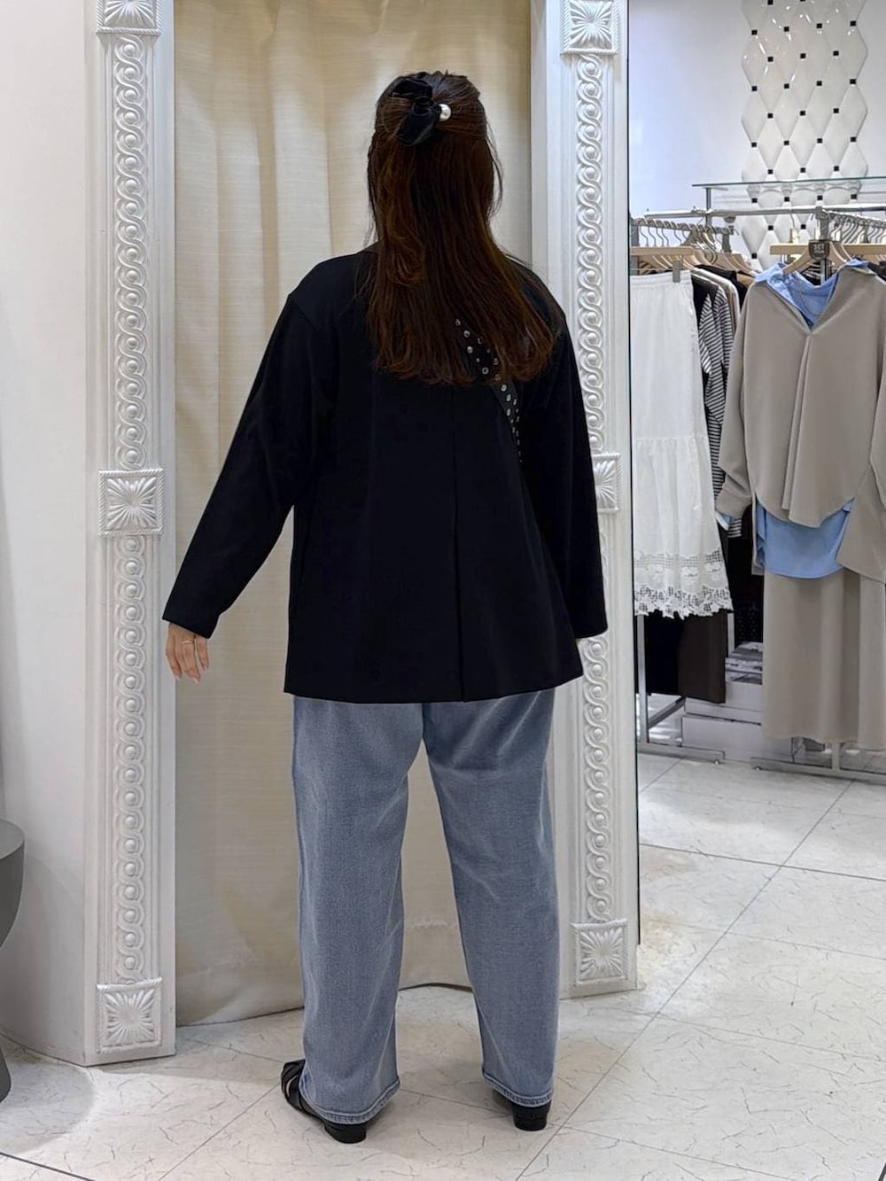 ブルー系のデニムパンツ、ブラック系のパンプス、ブラック系のボストンバッグを着用したレディースの春コーディネートの4枚目の写真