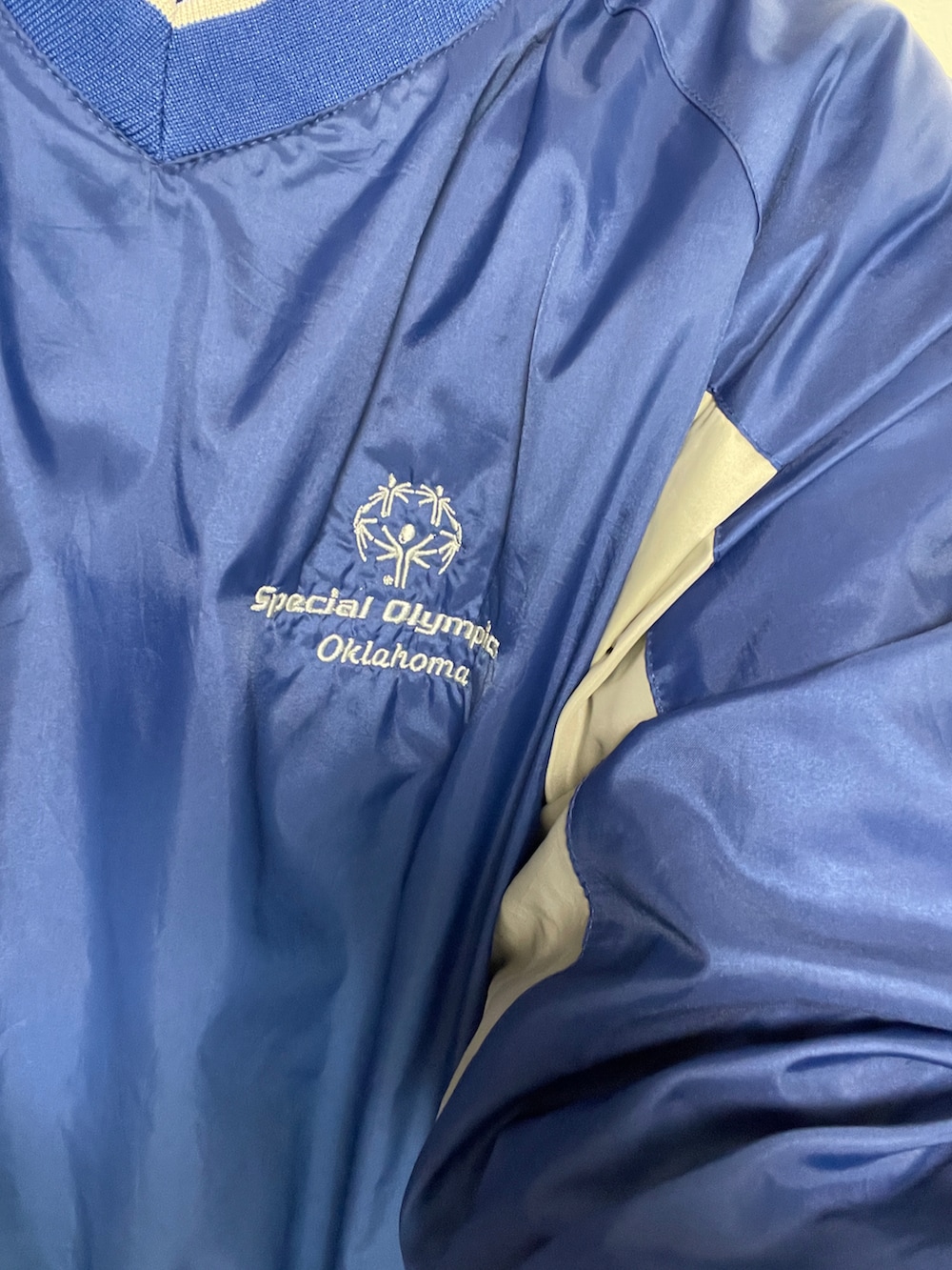 ブルー系のナイロンジャケット、グリーン系のカーゴパンツを着用したメンズの春コーディネートの2枚目の写真