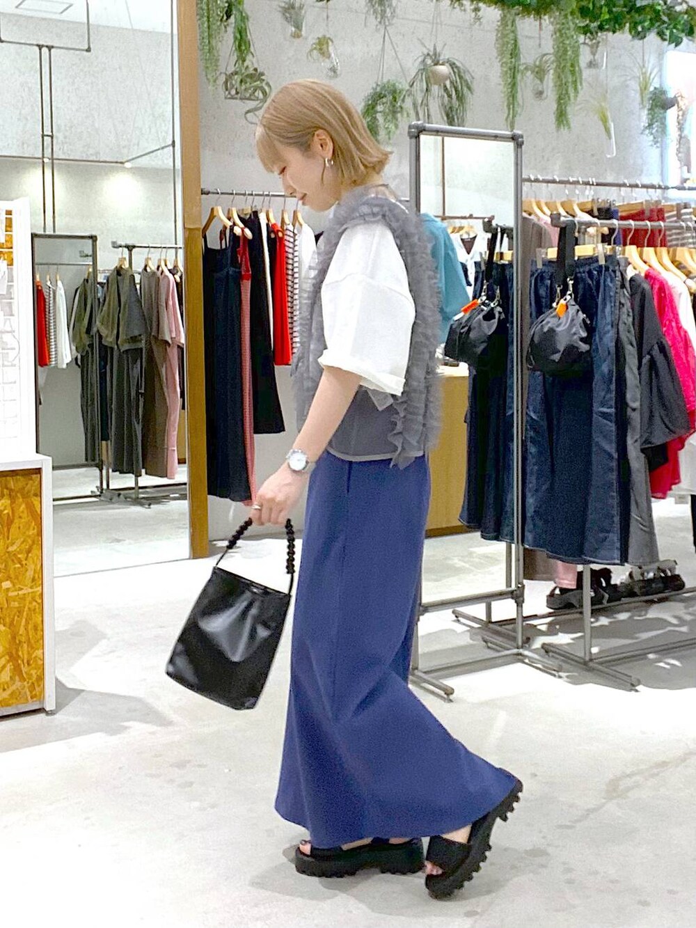 ブルー系のスカート、ブラック系のサンダル、ブラック系のショルダーバッグを着用したレディースの夏コーディネートの2枚目の写真