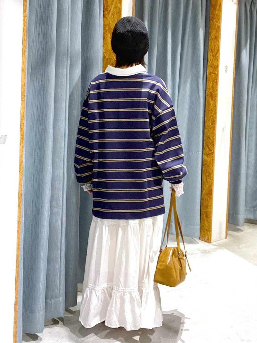 イエロー系のボストンバッグ、ブルー系のTシャツ/カットソー、ブラウン系のスニーカーを着用したレディースの冬コーディネートの3枚目の写真