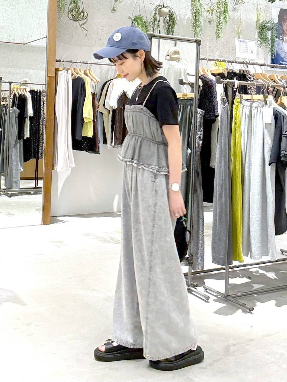 グレー系のデニムパンツ、ブラック系のトートバッグ、ブラック系のサンダルを着用したレディースの春コーディネートの2枚目の写真