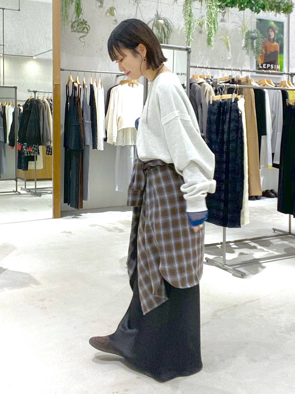 ブラック系のスカート、ブラウン系のスニーカー、ブラック系のボストンバッグを着用したレディースの冬コーディネートの2枚目の写真