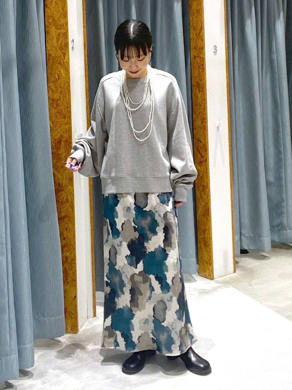 ブラック系のブルゾン、ブラック系のブーツ、ホワイト系のショルダーバッグを着用したレディースの冬コーディネートの4枚目の写真