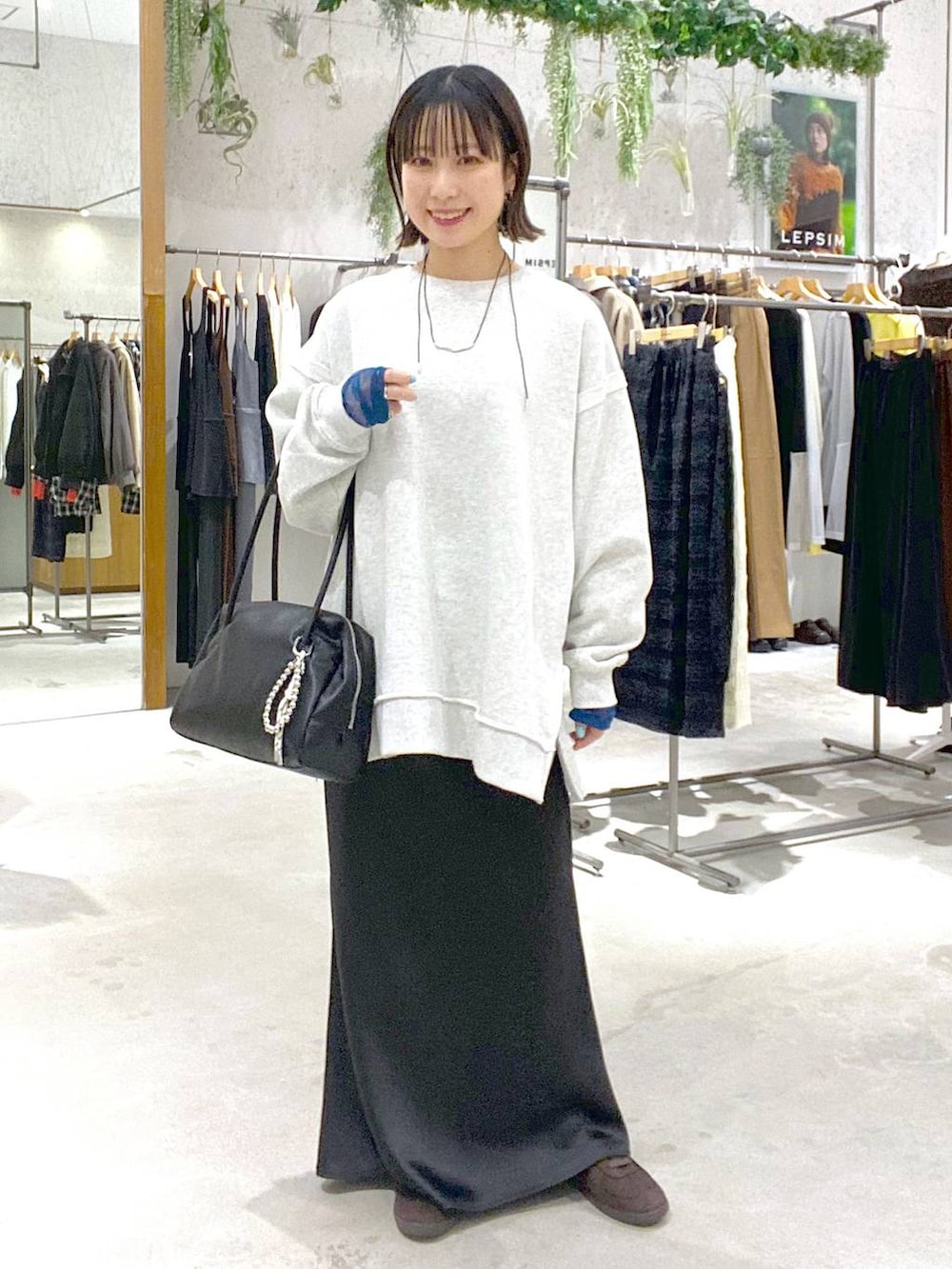 ブラック系のスカート、ブラウン系のスニーカー、ブラック系のボストンバッグを着用したレディースの冬コーディネートの4枚目の写真