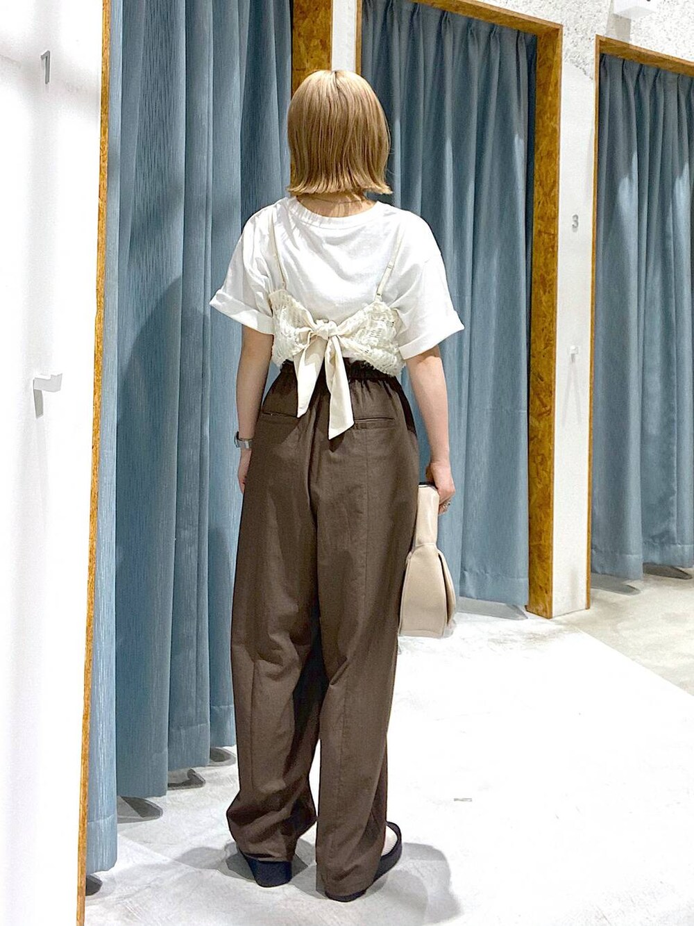 ホワイト系のサンダル、ベージュ系のハンドバッグ、ホワイト系のTシャツ/カットソーを着用したレディースの夏コーディネートの3枚目の写真