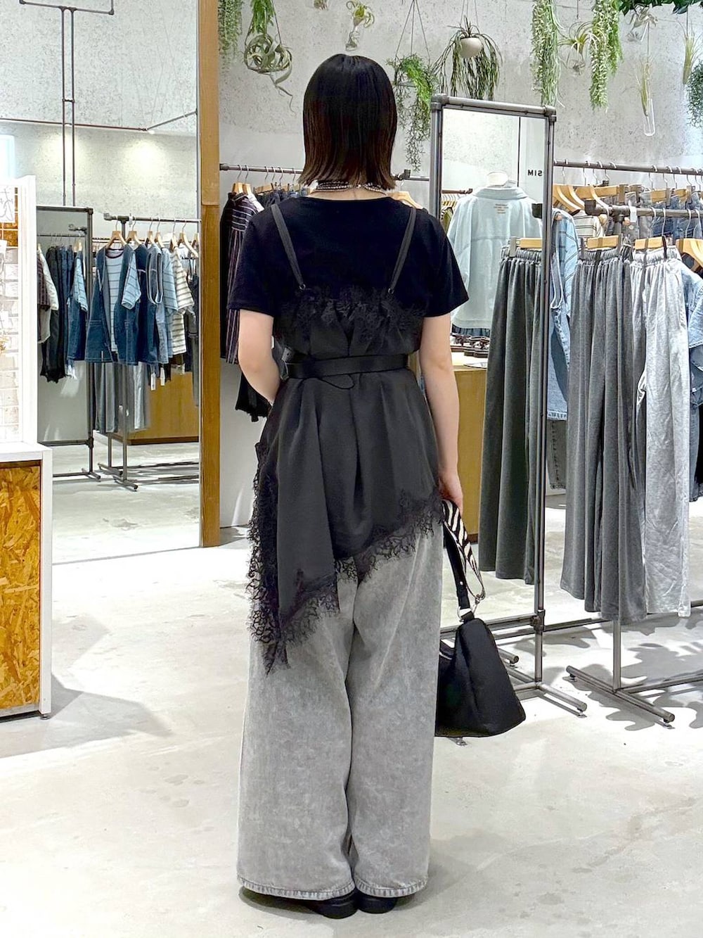 グレー系のデニムパンツ、ブラック系のサンダル、ブラック系のTシャツ/カットソーを着用したレディースの夏コーディネートの3枚目の写真