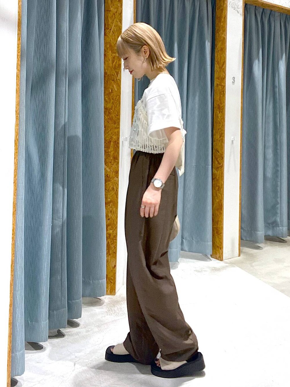 ホワイト系のサンダル、ベージュ系のハンドバッグ、ホワイト系のTシャツ/カットソーを着用したレディースの夏コーディネートの2枚目の写真