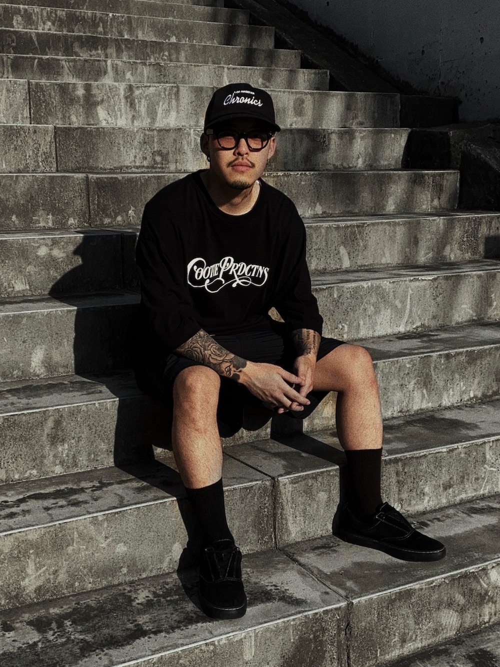 ブラック系のスニーカー、ブラック系のTシャツ/カットソーを着用したメンズの夏コーディネートの2枚目の写真