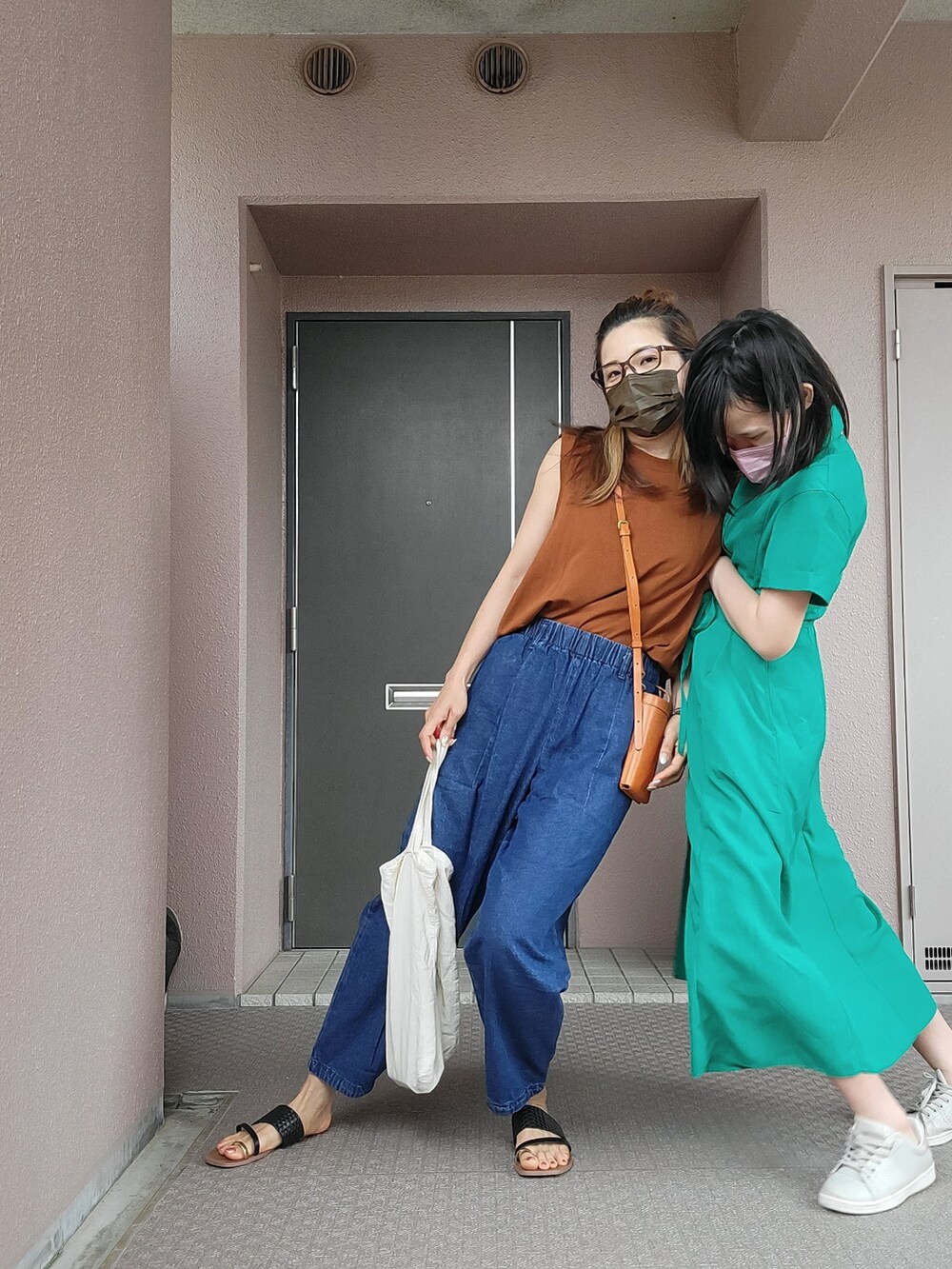 ブルー系のパンツ、イエロー系のショルダーバッグ、ブラウン系のトップスを着用したレディースの夏コーディネートの4枚目の写真