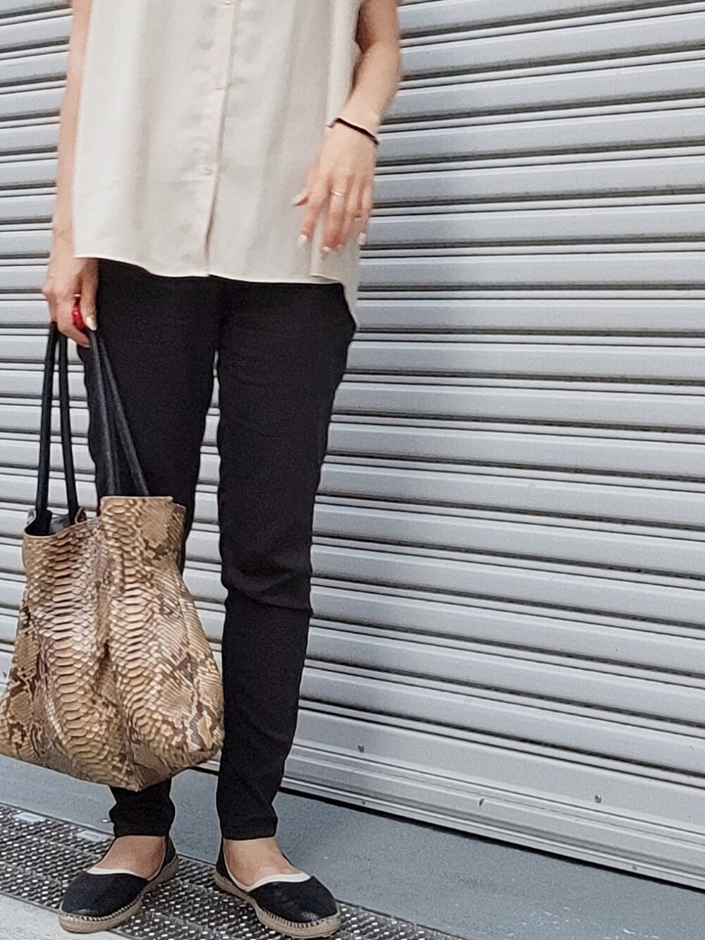 ブラック系のパンツ、ベージュ系のシャツ/ブラウス、ブラウン系のトートバッグを着用したレディースの夏コーディネートの2枚目の写真