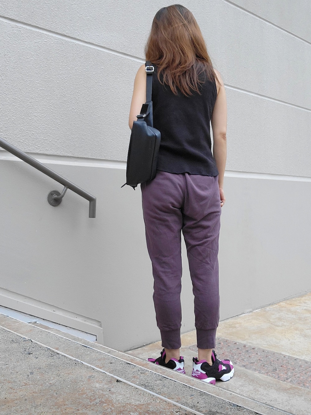 ブラウン系のスウェットパンツ、パープル系のスニーカー、ブラック系のタンクトップを着用したレディースの夏コーディネートの3枚目の写真