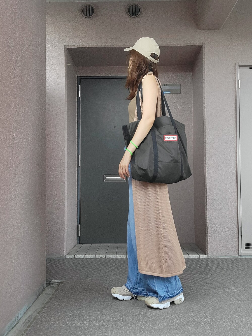 グリーン系のタンクトップ、ベージュ系のワンピース、ブルー系のデニムパンツを着用したレディースの夏コーディネートの3枚目の写真