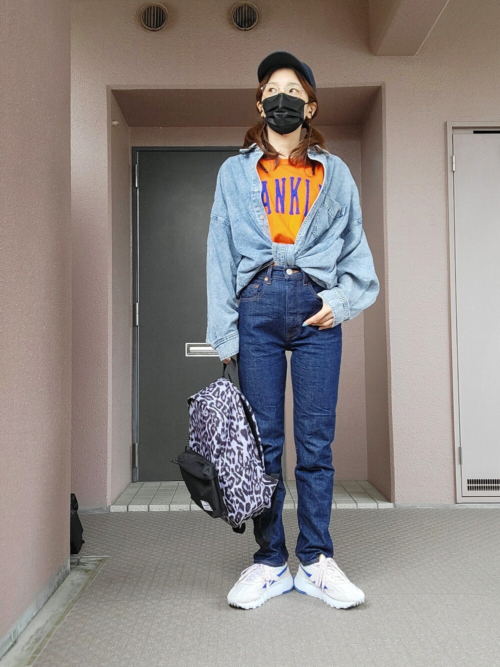 オレンジ系のTシャツ/カットソー、ブルー系のトップス、ブルー系のデニムパンツを着用したレディースの春コーディネートの3枚目の写真