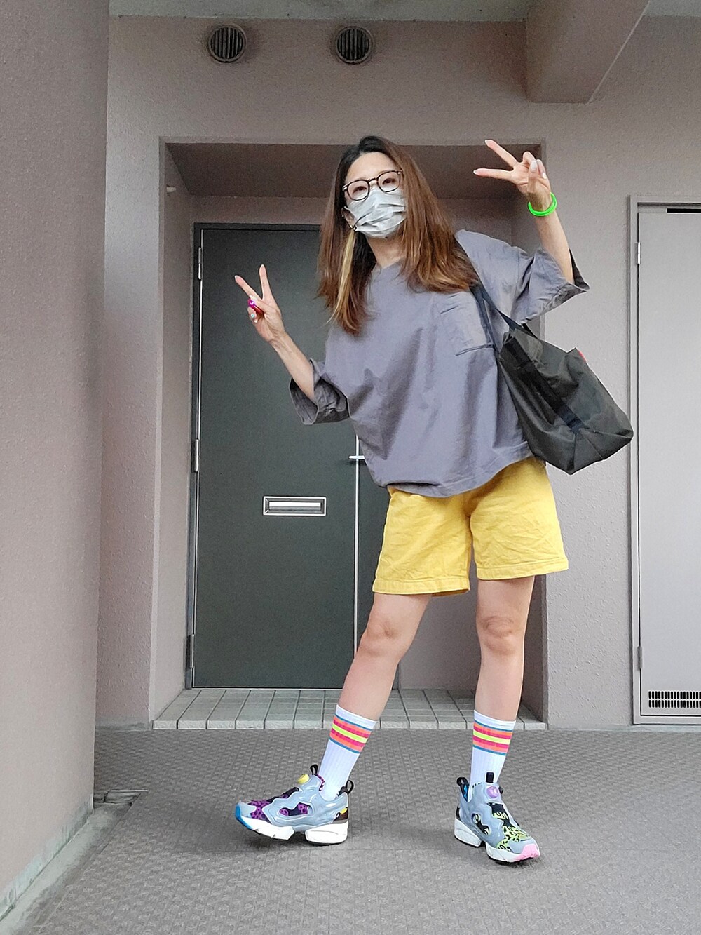 グレー系のTシャツ/カットソー、グリーン系のトートバッグ、イエロー系のパンツを着用したレディースの夏コーディネートの3枚目の写真