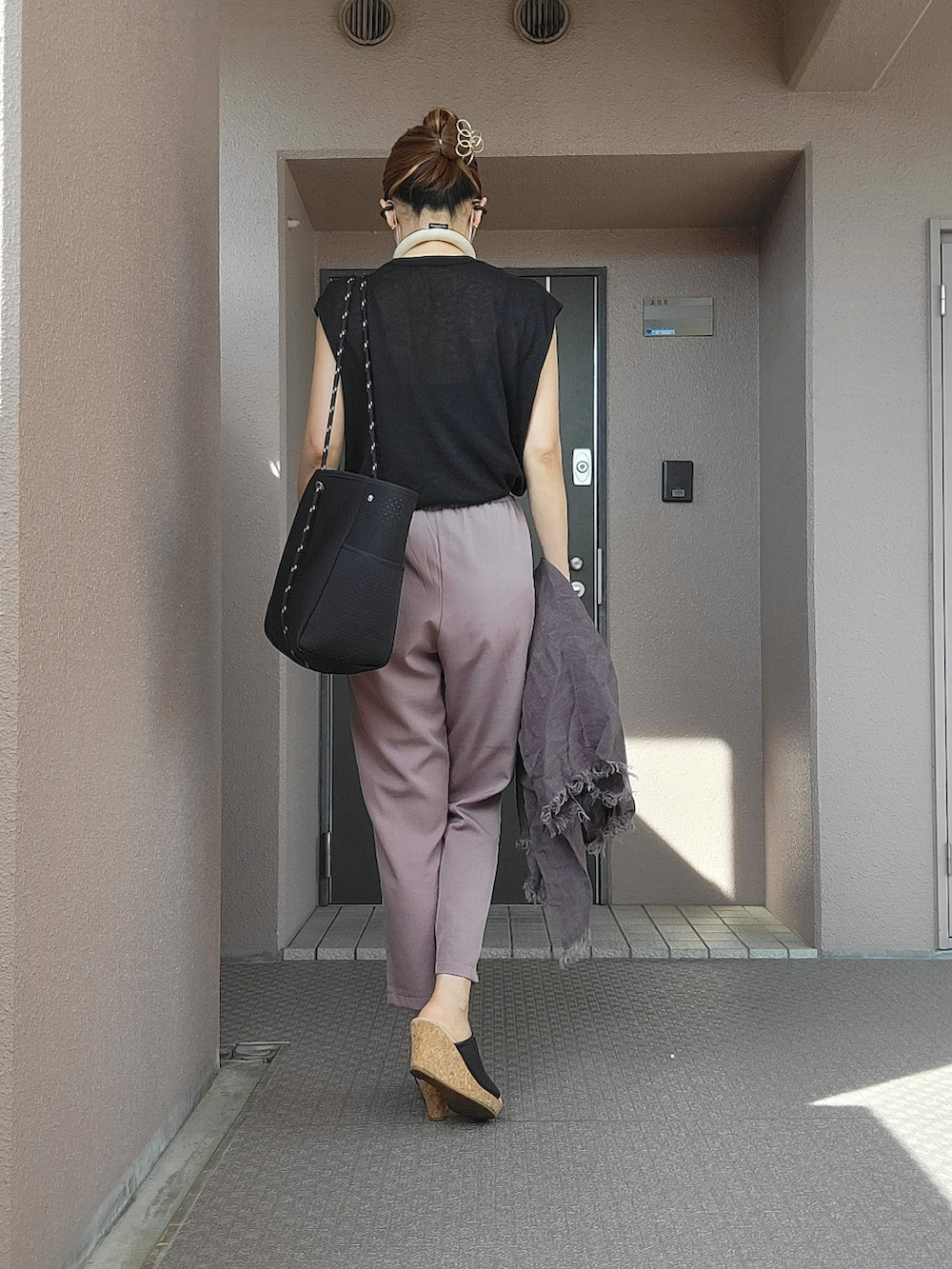 ブラウン系のセットアップ、ブラック系のサンダル、ブラック系のトートバッグを着用したレディースの夏コーディネートの3枚目の写真