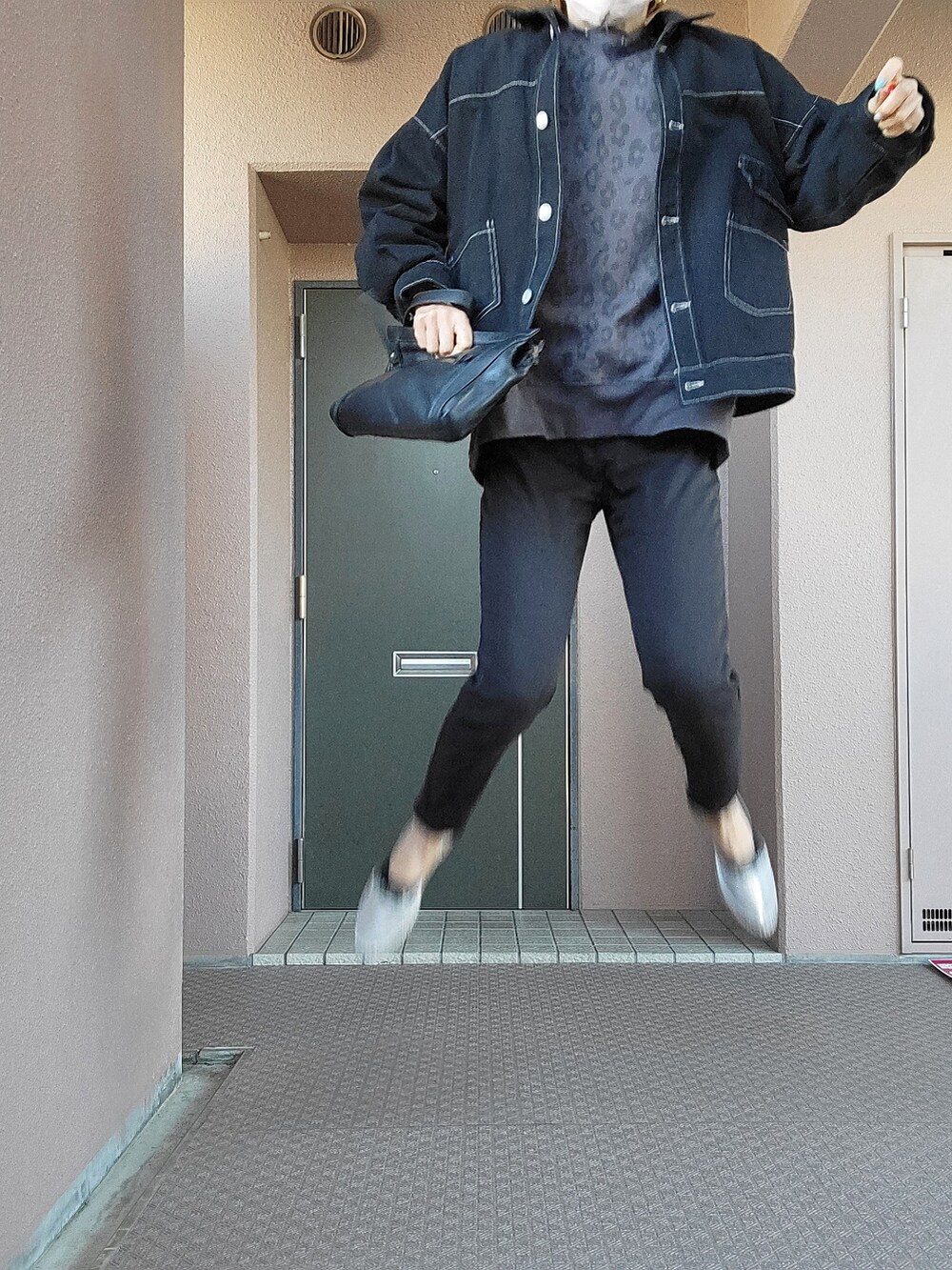 グレー系のスウェット、ブラック系のクラッチバッグ、ブラック系のパンツを着用したレディースの春コーディネートの4枚目の写真
