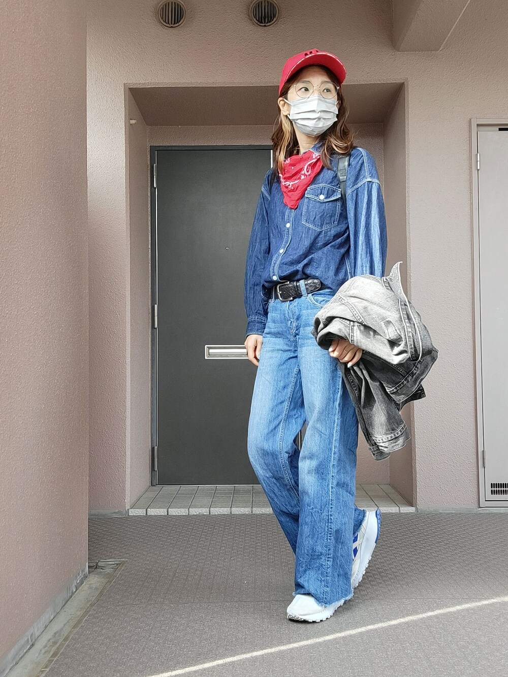 グレー系のスニーカー、ブルー系のデニムパンツ、ブラック系のデニムジャケットを着用したレディースの春コーディネートの2枚目の写真