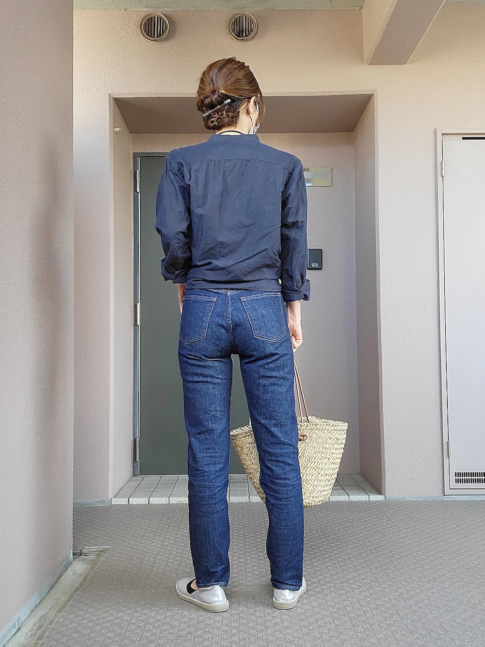 ベージュ系のかごバッグ、ブルー系のデニムパンツ、シルバー系のスリッポンを着用したレディースの春コーディネートの4枚目の写真