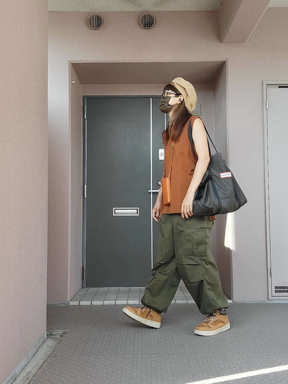 ブラウン系のトップス、グリーン系のトートバッグ、イエロー系のショルダーバッグを着用したレディースの秋コーディネートの3枚目の写真