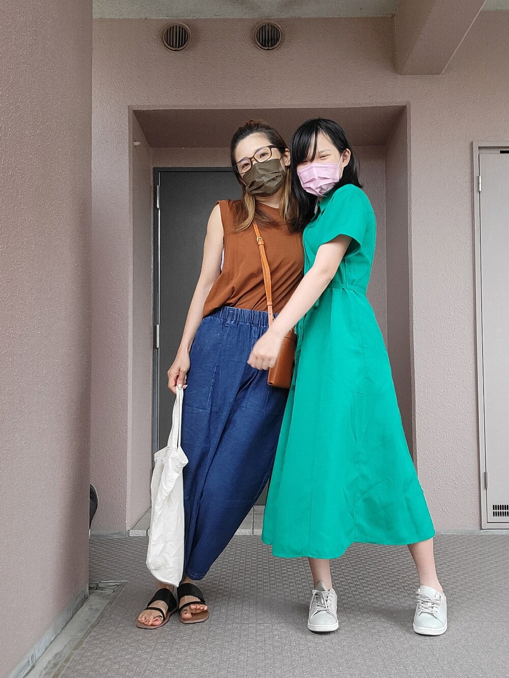 ブルー系のパンツ、イエロー系のショルダーバッグ、ブラウン系のトップスを着用したレディースの夏コーディネートの3枚目の写真