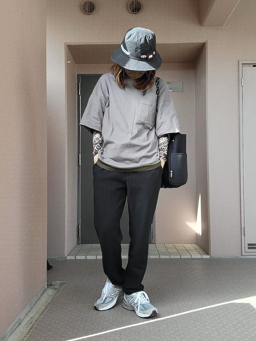 グレー系のスニーカー、ブラウン系のパンツ、グレー系のTシャツ/カットソーを着用したレディースの春コーディネートの2枚目の写真