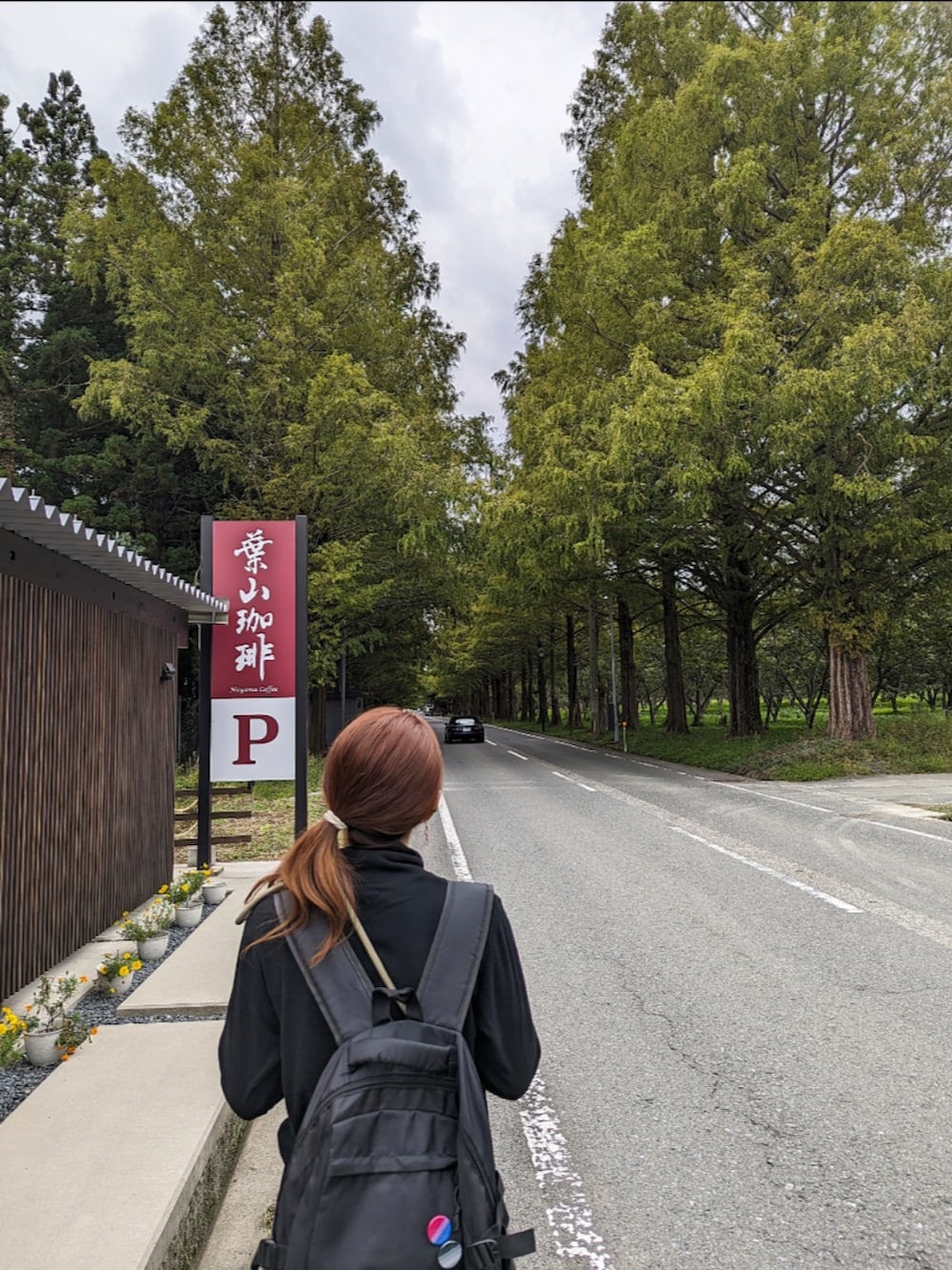 ブラック系のデニムパンツ、ブラック系のブーツ、ブラック系のバックパック/リュックを着用したレディースの秋コーディネートの2枚目の写真