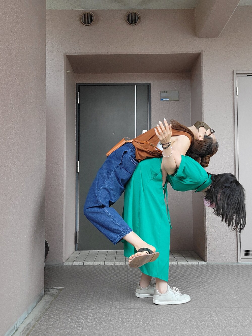 ブルー系のパンツ、イエロー系のショルダーバッグ、ブラウン系のトップスを着用したレディースの夏コーディネートの5枚目の写真