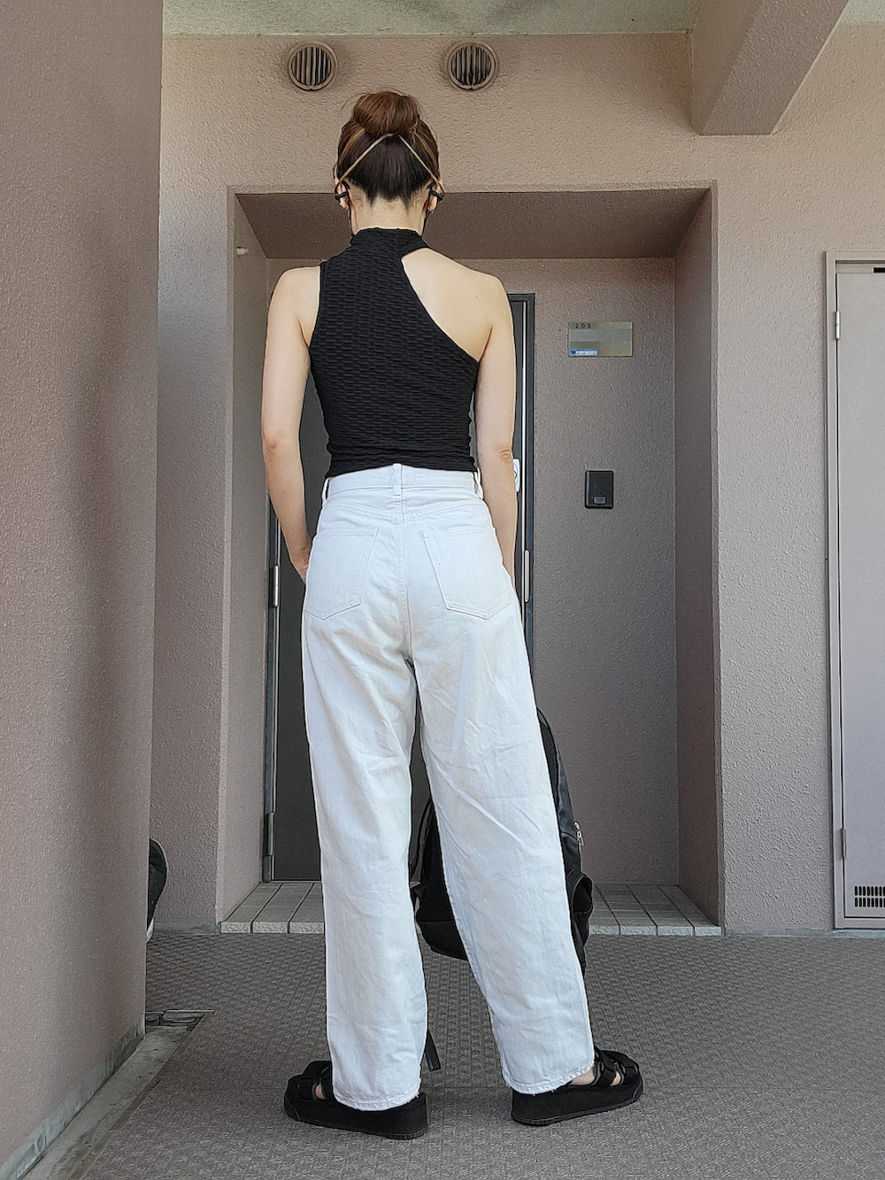 ブラック系のTシャツ/カットソー、ホワイト系のデニムパンツ、ブラック系のバックパック/リュックを着用したレディースの夏コーディネートの2枚目の写真