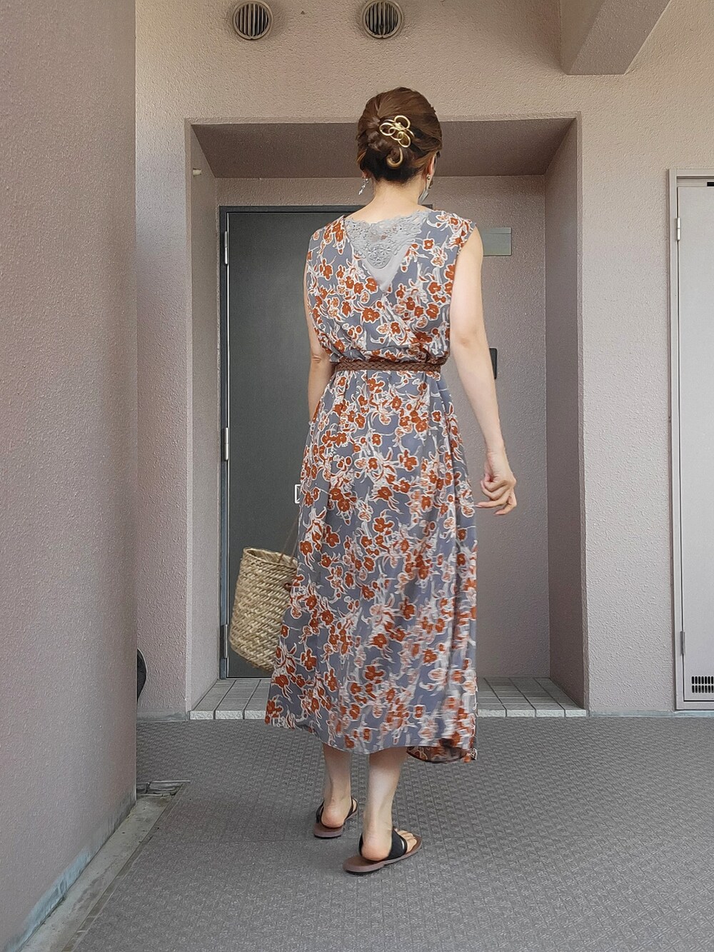 グレー系のワンピース、ベージュ系のかごバッグ、ブラック系のサンダルを着用したレディースの夏コーディネートの2枚目の写真