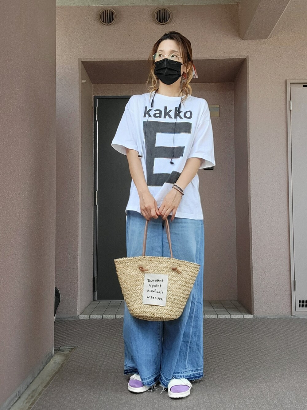 ベージュ系のかごバッグ、ブルー系のデニムパンツ、ホワイト系のサンダルを着用したレディースの春コーディネートの3枚目の写真