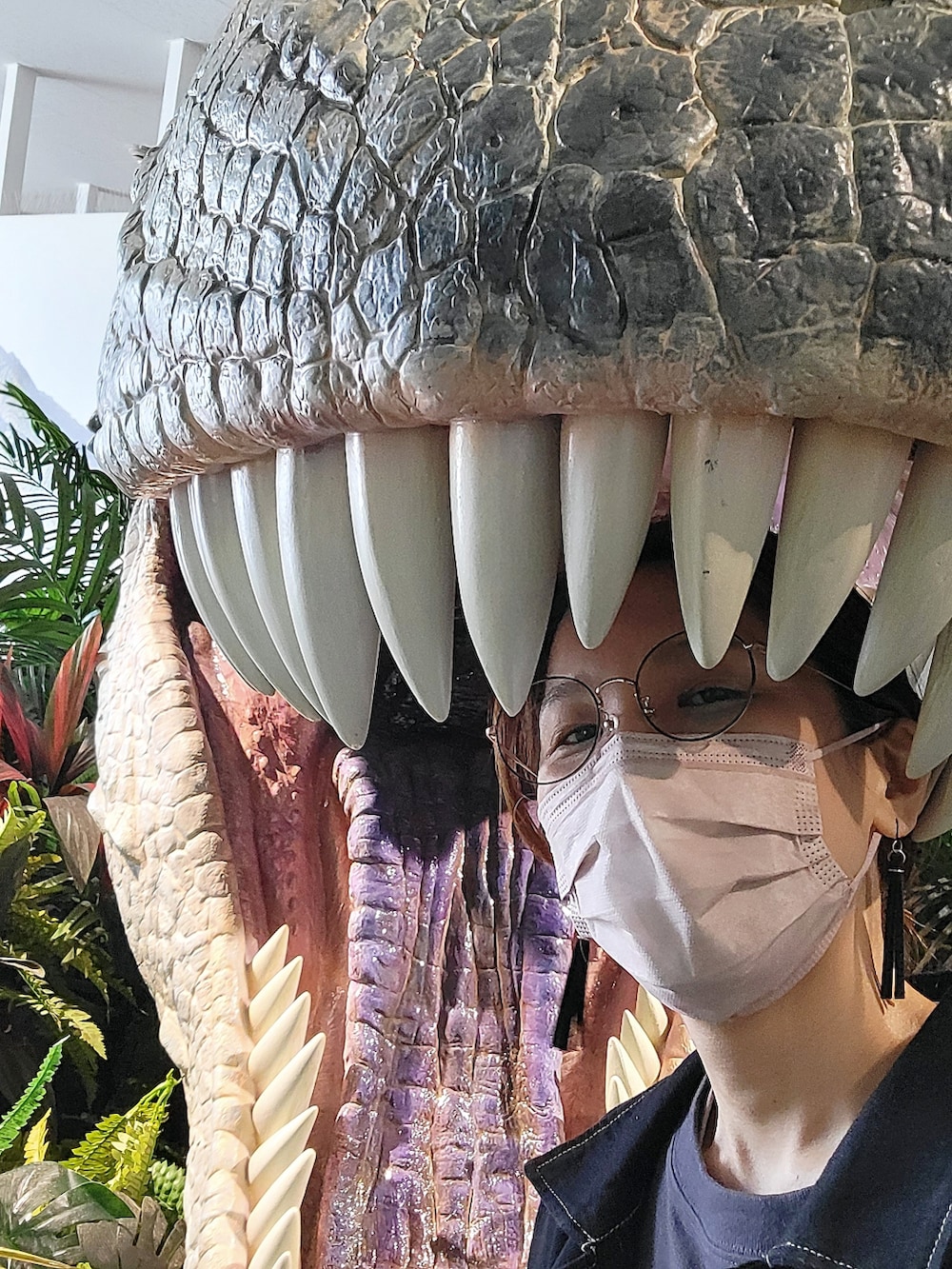 ブルー系のデニムジャケット、グレー系のワンピース、ブルー系のデニムパンツを着用したレディースの春コーディネートの3枚目の写真