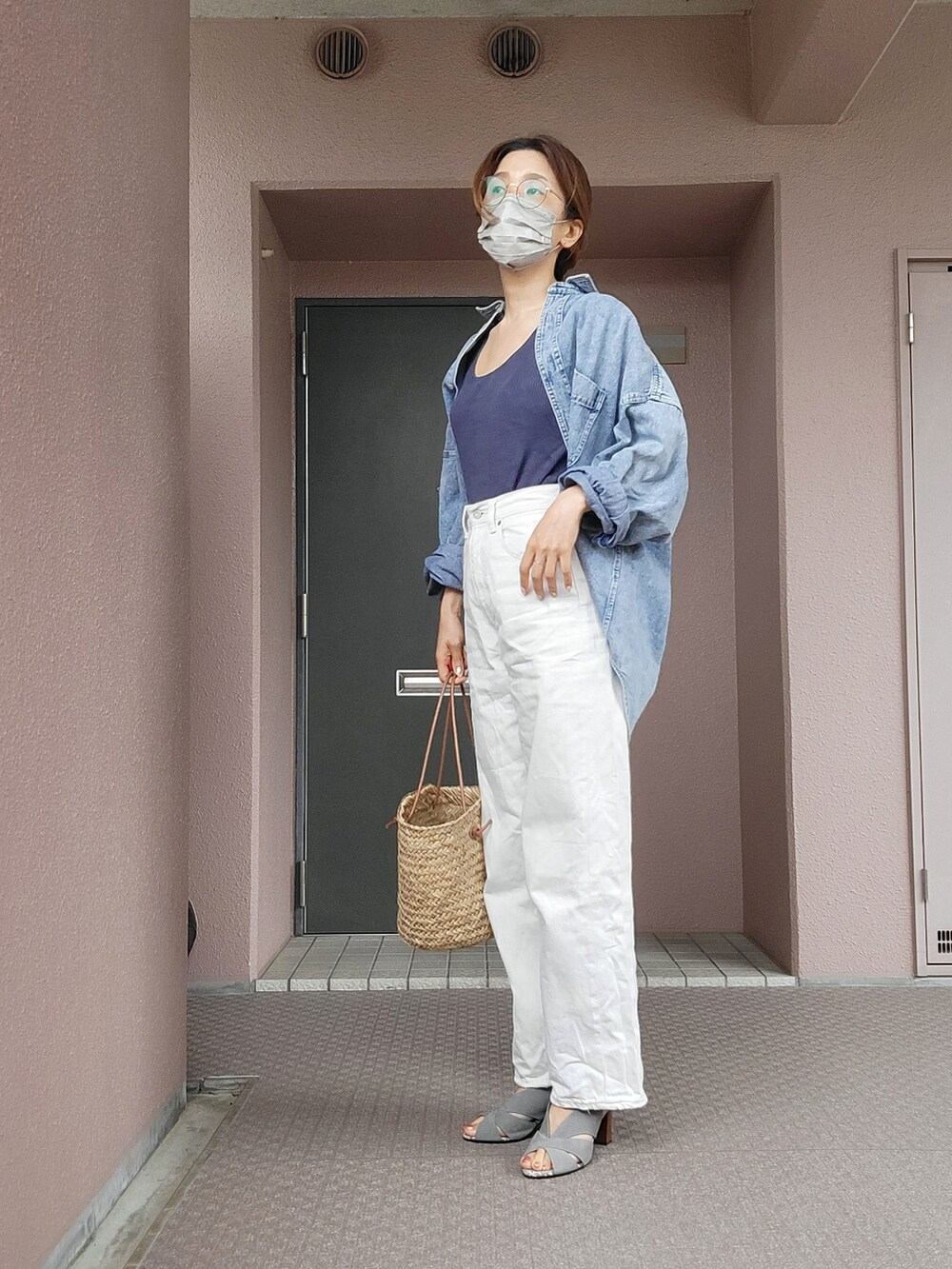 ホワイト系のデニムパンツ、ベージュ系のかごバッグ、グレー系のサンダルを着用したレディースの夏コーディネートの2枚目の写真