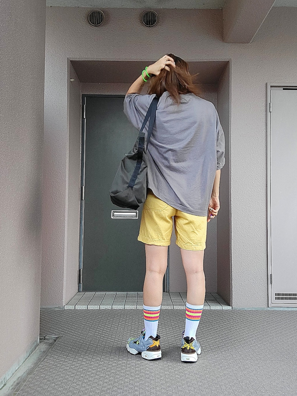 グレー系のTシャツ/カットソー、グリーン系のトートバッグ、イエロー系のパンツを着用したレディースの夏コーディネートの2枚目の写真