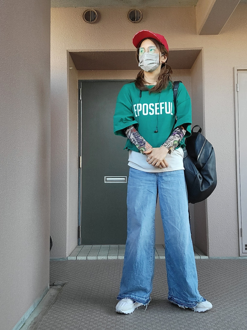 ブルー系のデニムパンツ、ブラック系のバックパック/リュック、グレー系のスニーカーを着用したレディースの夏コーディネートの2枚目の写真