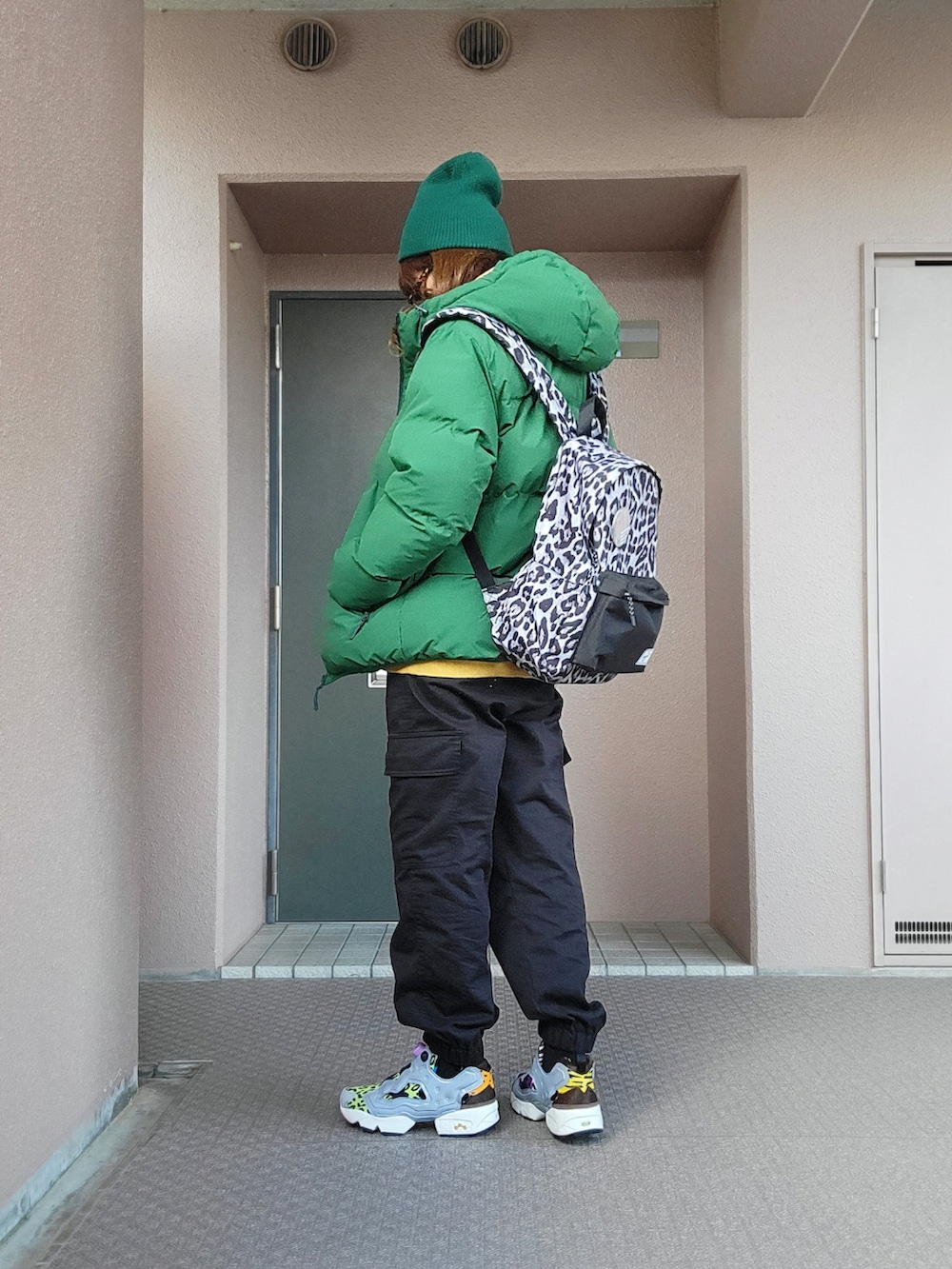 ブラック系のカーゴパンツ、その他のスニーカー、グリーン系のジャケット/アウターを着用したレディースの冬コーディネートの2枚目の写真