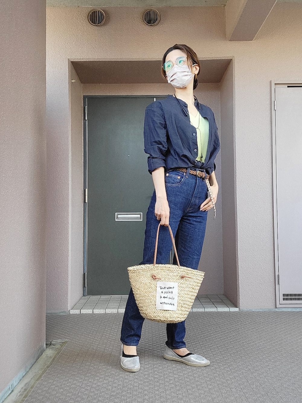 ベージュ系のかごバッグ、ブルー系のデニムパンツ、シルバー系のスリッポンを着用したレディースの春コーディネートの3枚目の写真