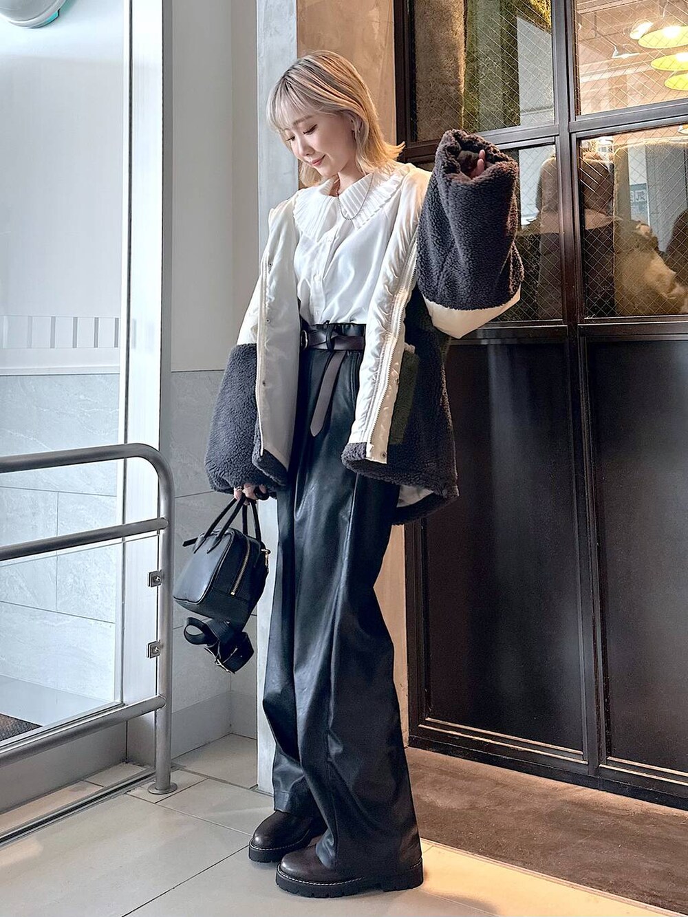 ブラック系のその他パンツ、ブラウン系のその他シューズ、ブラック系のショルダーバッグを着用したレディースの秋コーディネートの4枚目の写真