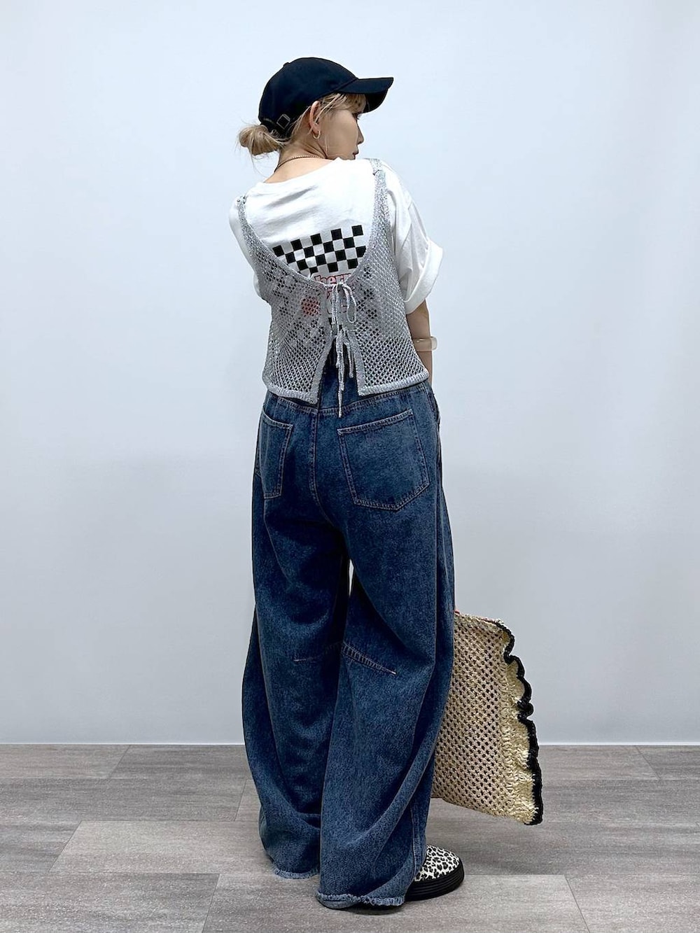 ベージュ系のトートバッグ、その他のスニーカー、ブルー系のデニムパンツを着用したレディースの夏コーディネートの5枚目の写真