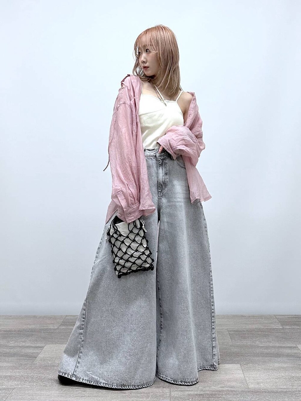 ブラック系のショルダーバッグ、ブラック系のサンダル、グレー系のデニムパンツを着用したレディースの春コーディネートの4枚目の写真