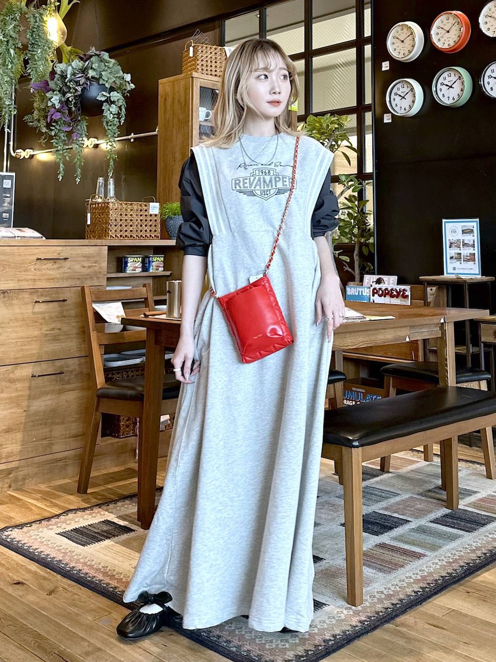 レッド系のショルダーバッグ、ブラック系のパンプス、ベージュ系のワンピースを着用したレディースの春コーディネートの2枚目の写真