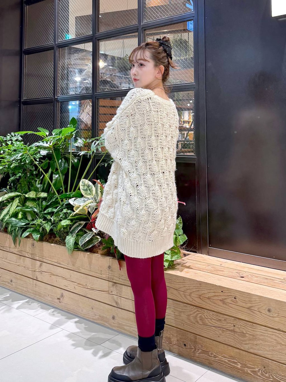 ブラウン系のショルダーバッグ、ブラウン系のブルゾン、ベージュ系のニット/セーターを着用したレディースの冬コーディネートの2枚目の写真