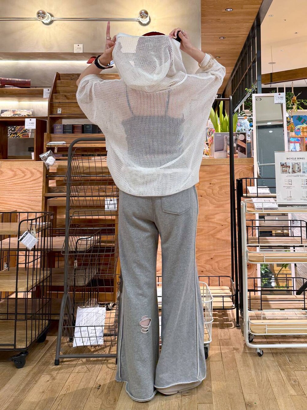 グレー系のその他パンツ、ホワイト系のパーカー、ベージュ系のサンダルを着用したレディースの春コーディネートの2枚目の写真
