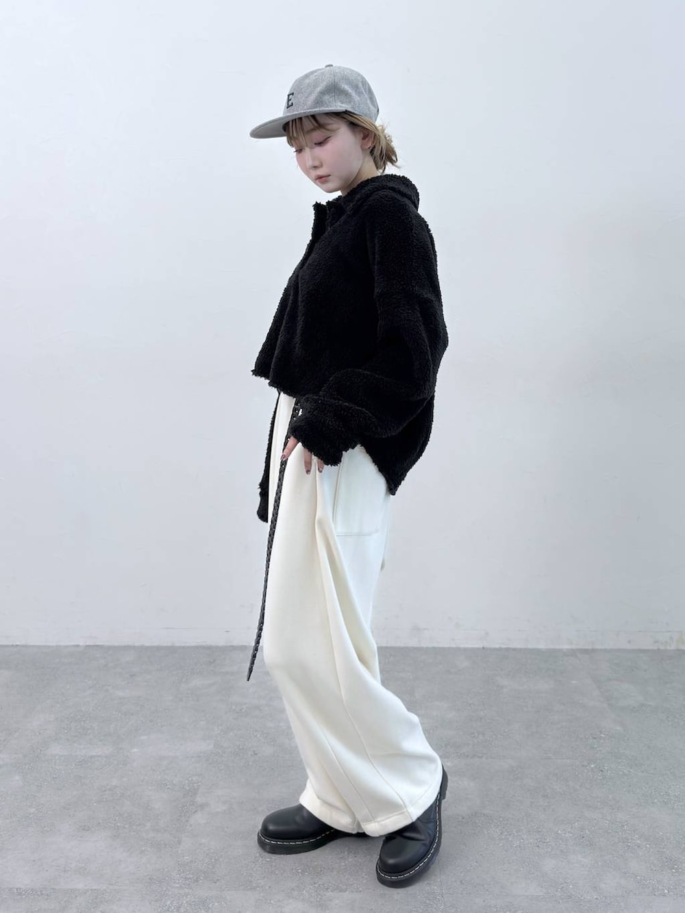 ベージュ系のその他パンツ、ブラック系のポロシャツ、グレー系のキャップを着用したレディースの秋コーディネートの2枚目の写真