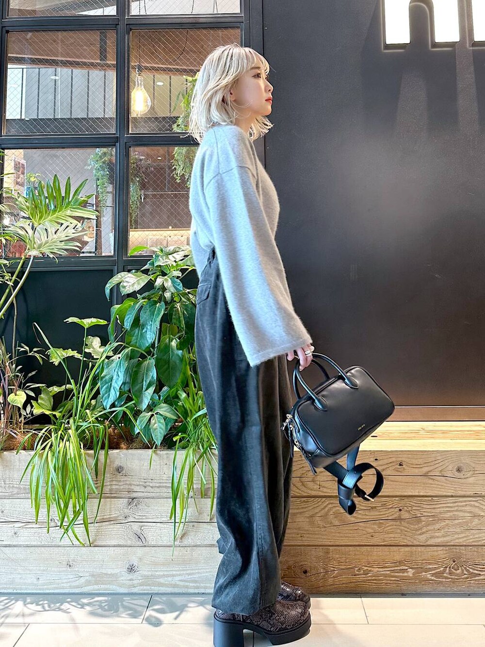 ブラウン系のニット/セーター、その他のブーツ、ブラック系のショルダーバッグを着用したレディースの秋コーディネートの2枚目の写真