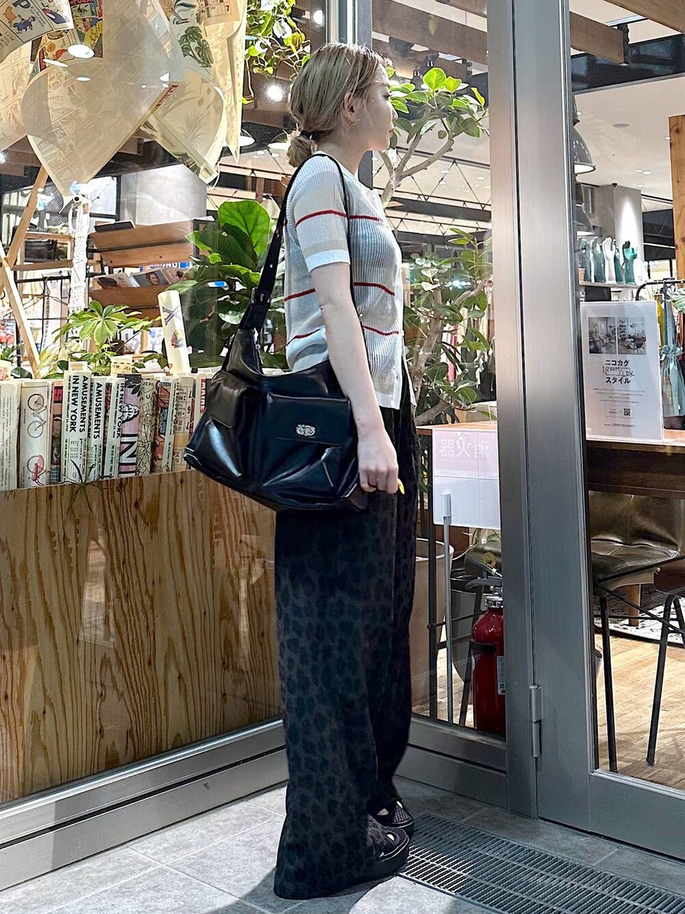 ブラック系のショルダーバッグ、グレー系のその他パンツ、ホワイト系のカーディガン/ボレロを着用したレディースの春コーディネートの2枚目の写真